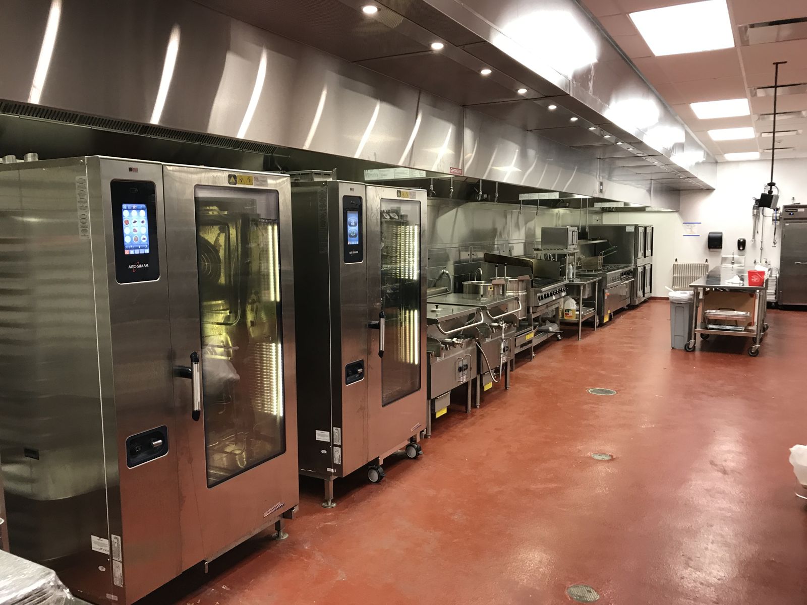 Combi ovens along a stainless cookline under an exhaust hood